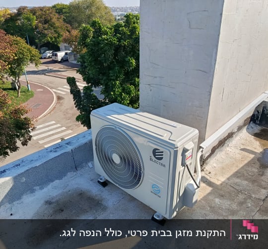 יחידת מיזוג אוויר על גג עם נוף עצים ורחוב